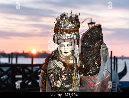 Venedig, Italien, 11. Februar, 2018. Leute in Kostümen stellen in der Dämmerung bei einem wunderschönen Sonnenaufgang in der Nähe von St Mark's Squarei während der Karneval von Venedig. Credit: Cjm/Alamy Leben Nachrichten. Stockfoto