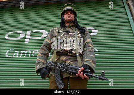 Srinagar, Indien. 11 Feb, 2018. Eine Indische paramilitärischen Soldat steht Alert in der Nähe von geschlossenen Geschäften beim Herunterfahren in Srinagar, Indien verwalteten Kaschmir. Sperrstunde - wie Beschränkungen haben in Teilen von Srinagar Stadt verhängt wurde in der Folge eines Aufrufs zur Streik der separatistischen Gruppen den Tod Jubiläum der Maqbool Bhat, Jammu und Kashmir Liberation Front (JKLF) Gründer, die sich in Delhi vor 34 Jahren gehängt wurde. In anderen Teilen des Tales, eine komplette Abschaltung beobachtet wird zu gedenken. Geschäfte, Betriebe geschlossen sind und nur sehr wenige Fahrzeuge sind auf den Straßen gesehen. maqbool Bhat war Han Stockfoto