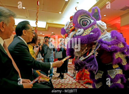 Los Angeles, USA. 10 Feb, 2018. Geben Sie den Leuten rote Taschen zu einem tanzenden Löwen im Millennium Biltmore Hotel in Los Angeles, USA, 10.02.2018. Die Zeremonie der Erhellen Los Angeles war hier gefolgt von Drachen- und Löwentanz am Samstag chinesische Mondjahr von Hund zu Feiern statt. Credit: Li Ying/Xinhua/Alamy leben Nachrichten Stockfoto