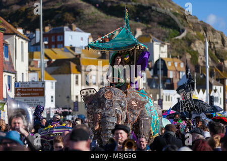 Hastings, East Sussex, UK. 11 Feb, 2018. Hastings Fat Tuesday ist als größter Mardi Gras Feier des Vereinigten Königreichs, die Vitrinen Hastings 'lebendigen Musik Szene und ist über 5 Tage zwischen dem 9. bis 13. Februar statt, heute in Rechnung gestellt Sonntag ist der 'Umbrella Parade", wo alle, die Sie benötigen, teil zu nehmen, ist ein verzierter Regenschirm. Hunderte Menschen säumen die Küste wie die bunte Sonnenschirme. Foto: Paul Lawrenson/Alamy leben Nachrichten Stockfoto