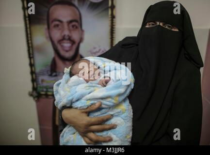 In Gaza. 11 Feb, 2018. Eine Palästinenserin hält Ihr neugeborenes Baby in einem Krankenhaus in Gaza Stadt, Jan. 11, 2018. Der Test-tube Baby namens Mujahid, wurde geboren mit dem geschmuggelt Spermien von seinem Vater, verurteilt worden ist, für sieben Jahre, die sich in israelischer Haft. Viele palästinensische Frauen mit Männern mit langen Laufzeiten in israelischen Gefängnissen zu schleichen und Spermien schwanger zurückgegriffen. Credit: Wissam Nassar/Xinhua/Alamy leben Nachrichten Stockfoto