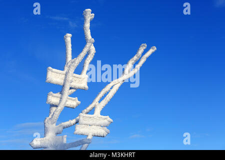 Gefrorene Wegweiser im Schnee im Winter bei Velika Planina, Slowenien. Stockfoto