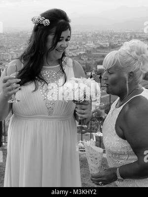 4. AUGUST 2017, TÜRKEI: Eine Braut mit einem Hochzeitsgast, der bei ihrer Hochzeit in der türkei am 4. august 2018 den Blumenstrauß riecht Stockfoto