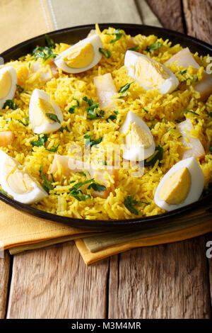 Traditionelles Essen: Kedgeree Reis mit geräuchertem Fisch, Eier, Gemüse und Gewürze close-up auf einem Teller. Vertikale Stockfoto