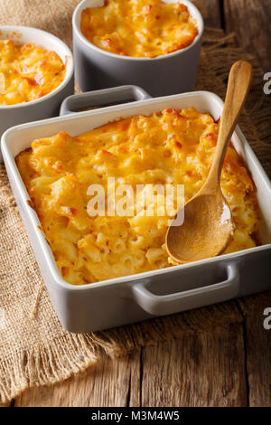 Amerikanische Auflauf Makkaroni und Käse in Auflaufform in der Nähe auf dem Tisch. Vertikale Stockfoto