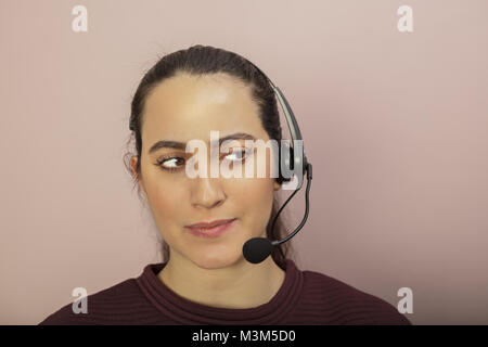 Nachdenklich Call Center Betreiber um ein Gespräch zur Seite, die mit einem nachdenklichen Ausdruck und leise wissendes Lächeln Stockfoto