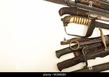 Sammlung von Vintage Waffen mit der hilts der alten Schwerter und Dolche bilden eine Seite über Weiß mit Kopie Raum Stockfoto