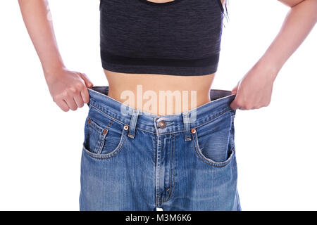 Nahaufnahme der Frau zeigen Ihr Gewicht Verlust und tragen Ihre alte Jeans auf weißem Hintergrund Stockfoto