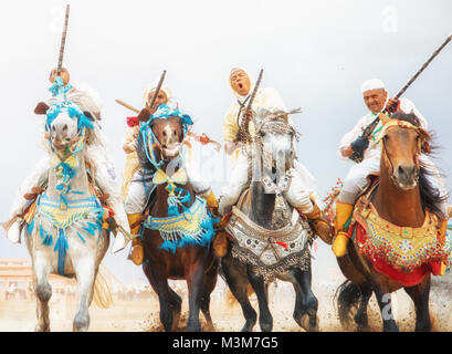 Pferde und Reiter laden mit den Pferden und schießen Musketen reenacting Krieg Angriff Szenen Mzoudia Tbourida in Marokko Stockfoto