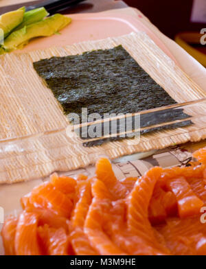Vorbereitung der Japanischen rollt von Lachs. Rollt auf Holzbrett Stockfoto