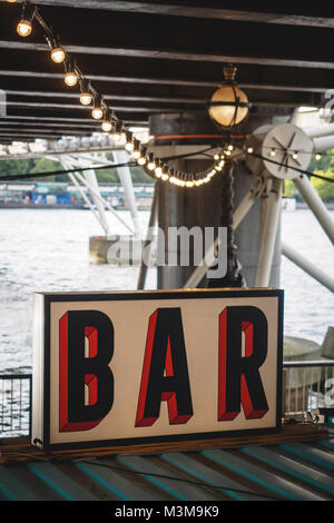 Vintage Schild mit roter und schwarzer Schrift auf weißem Hintergrund mit einer Reihe von Lampen leuchten. Hochformat. Stockfoto