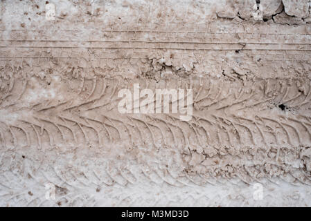 Schmutzige Spuren der Lauffläche auf der schneebedeckten Straße. Im Winter Spuren von Schnee vom Auto. Stockfoto