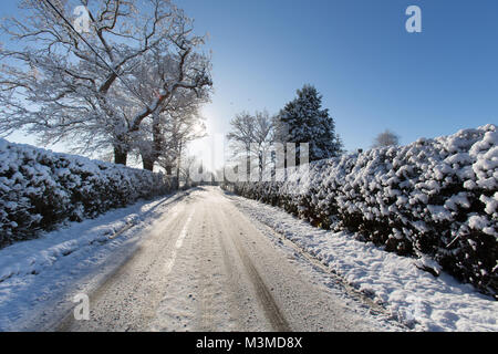 Dorf von Coddington, England. Silhouetted winter Blick eines ländlichen nicht knirschte Straße, in ländlichen Cheshire. Stockfoto