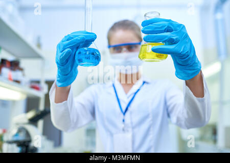 Wissenschaftlerin Holding Bechergläser Stockfoto