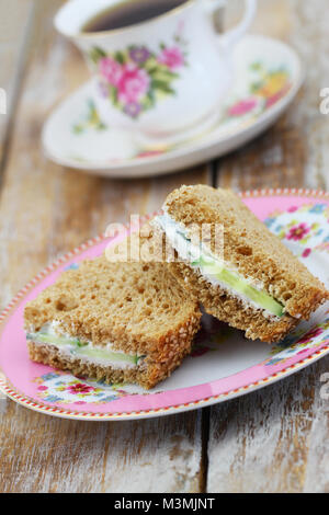 Tea Time mit braunen Frischkäse und Gurke Sandwiches mit Kaffee in vintage Schale Stockfoto
