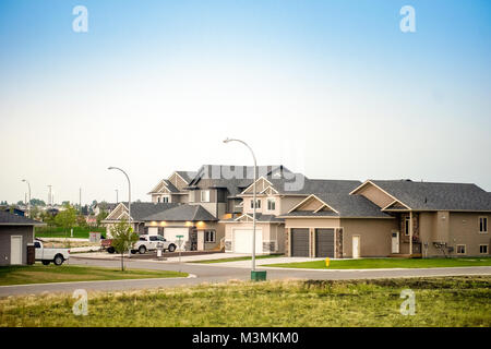 Große kanadische Häuser mit Fahrstraßen und Autos und blauer Himmel über Stockfoto
