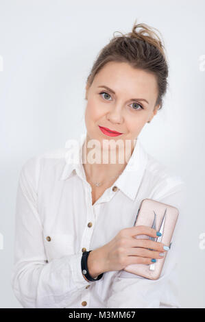 Closeup Portrait von weiblichen Visagist mit Augenbraue Tweezerson und charmantes Lächeln auf weißem Hintergrund. Stockfoto