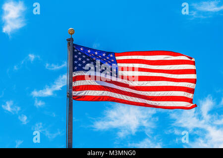 Die amerikanische Flagge schwenkten in der Luft mit einem klaren blauen Himmel im Hintergrund. Stockfoto