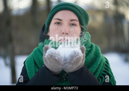 Jugendlich Mädchen bläst frischen Schnee in kalten Wintertag Stockfoto