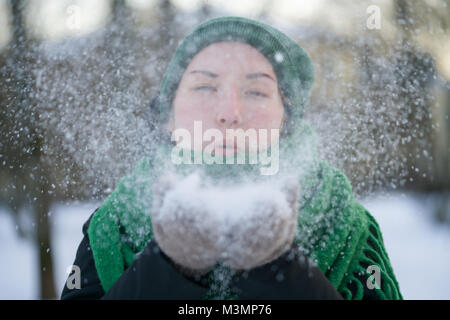 Jugendlich Mädchen bläst frischen Schnee in kalten Wintertag Stockfoto