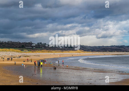 Menschen Flanieren auf der Newton Strand Porthcawl an einem windigen, sonnigen Wintertag, South Wales South Wales Coast, South Wales Küste, Stockfoto