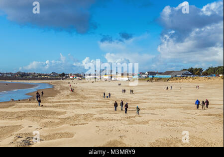 Sandy Bay, Porthcawl, mit Menschen für einen Spaziergang an einem sonnigen und windigen Wintertag, South Wales Stockfoto