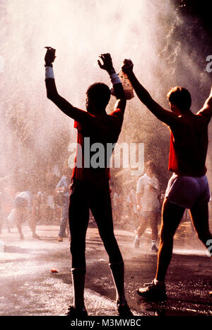 Marathonläufer Abkühlen im Wasser spray am Ende ihrer Rasse Stockfoto