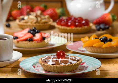 Schokoladentorte mit einer Auswahl von obstkuchen im Hintergrund Stockfoto