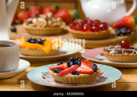 Erdbeere und Heidelbeere Tarte mit einer Auswahl von obstkuchen im Hintergrund Stockfoto