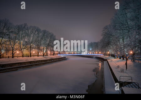 Schöne Aussicht auf den Fluss Aura mit Frost bedeckt Eichen auf den Seiten von straßenlaterne beleuchtet und Dom schwach im Hintergrund gesehen Ich Stockfoto