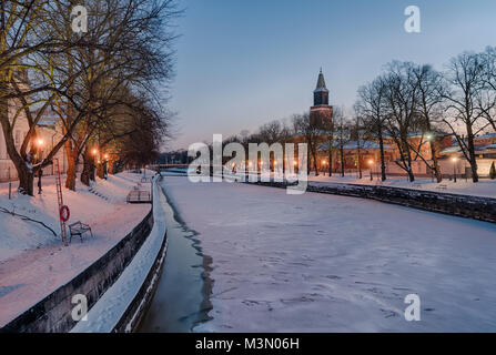 Schöne Aussicht auf den Fluss Aura an klaren Wintermorgen mit Straßenbeleuchtung auf und Turku Dom im Hintergrund Stockfoto