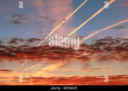 Red morgen Wolken und Streams der kondensierten Dampf auf dem Himmel Stockfoto