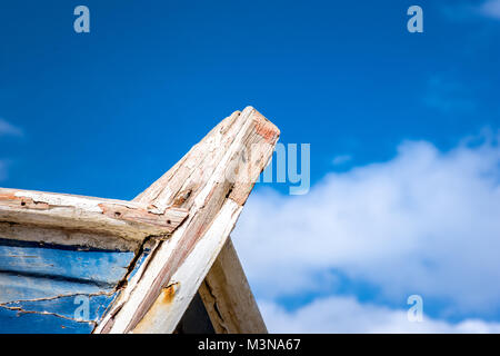 Detail eines hölzernen Schiffbruch mit Wolken und blauer Himmel. Stockfoto