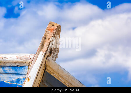 Detail eines hölzernen Schiffbruch mit Wolken und blauer Himmel. Stockfoto