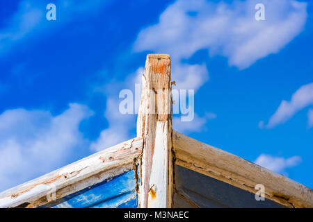 Detail eines hölzernen Schiffbruch mit Wolken und blauer Himmel. Stockfoto