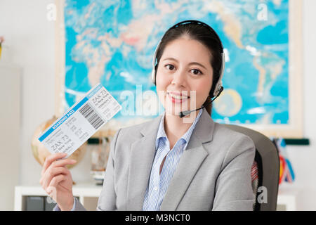 Selbstbewussten jungen Geschäftsfrau arbeiten an Reisebüro Firma online Service Center und das Tragen der Kopfhörer, Airline Ticket Gesicht zur Kamera. Stockfoto