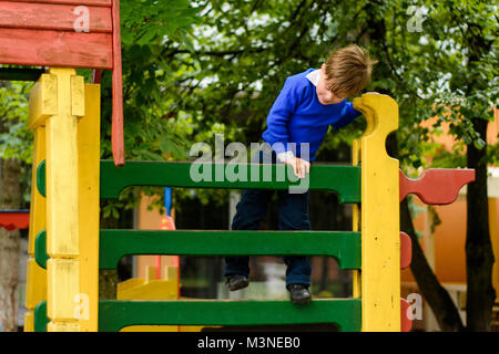 Schöne Ukrainische Jungen laufen auf einem Spielplatz und Abstieg von den Hügeln Stockfoto