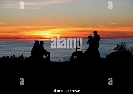 Freunde genießen die dramatischen Sonnenuntergang über dem Pazifischen Ozean, Big Sur, Kalifornien. Stockfoto