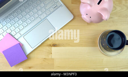 Moderne Büro Schreibtisch Overhead mit Sparschwein, Kaffee und Computer Laptop, mit kopieren. Stockfoto