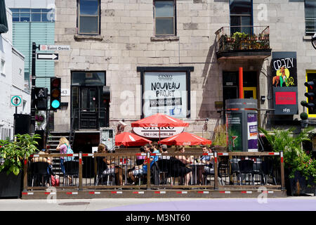 Menschen essen auf einer Terrasse an einem sonnigen Sommertag. St-Denis Street, Montreal, Quebec, Kanada. Stockfoto