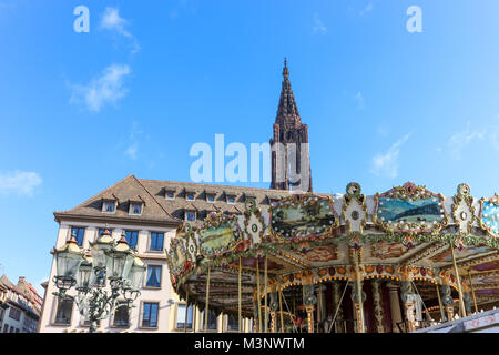 Karussell am Place Gutenberg in Straßburg, Frankreich. Die Kathedrale kann im Hintergrund gegen die blauen Sommerhimmel gesehen werden. Stockfoto