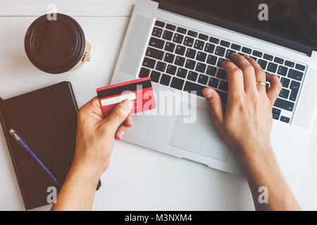 Mann bei der Arbeit am Laptop auf weißem Schreibtisch platziert Stockfoto