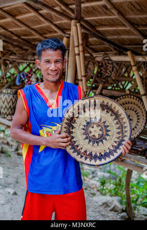 Aninuan, Oriental Mindoro, Philippinen - ein mangyanen Handwerkerin zeigt eine nito platter Sie aus Rattan Streifen an seinem Dorf Sitio Talipanan webten. Stockfoto