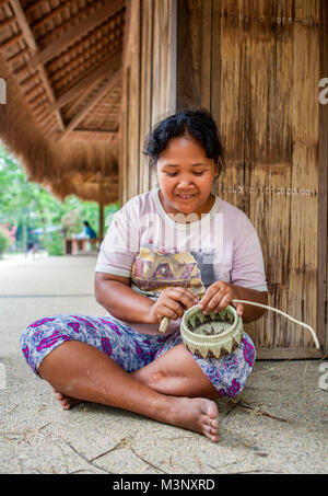 Aninuan, Oriental Mindoro, Philippinen - ein mangyanen Handwerkerin webt einen Korb in ihrem Dorf Sitio talipanan in Oriental Mindoro, Philippinen. Stockfoto