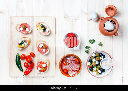 Auswahl an Tapas und Pinchos Snacks auf hellem Holz Tisch Schuß von oben Stockfoto