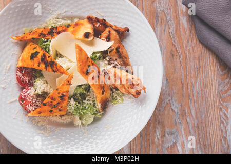 Caesar Salad mit gegrilltem Hähnchenbrustfilet Parmesan Tomatensoße Stockfoto