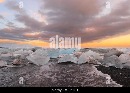 Isländischen Gletscher Jokulsarlon mit Eisberge am Strand bei Sonnenuntergang Stockfoto