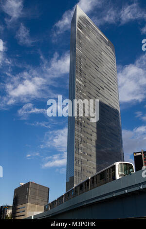 Ein Yurikamome-Zug fährt am Dentsu-Firmengebäude in Shiodome, Shimbashi, Tokio, Japan, vorbei. Stockfoto