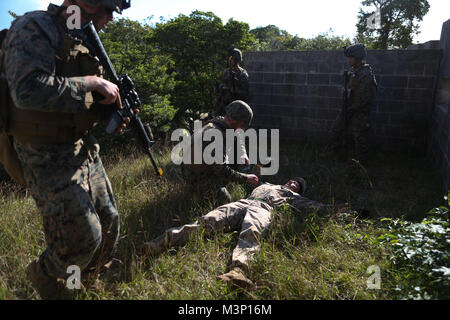 Marines mit 3. Marine Logistik Hauptsitz der Gruppe Suche einen fiktiven Geiselnahme während einer post-Befehl Übung bei der Stadt, die Marine Corps Base Camp Butler, Okinawa, Japan, Dez. 12, 2017. Die CPX wurde eine 4-tägige Feldübung entworfen, um die Grenzen der 3. MLG in seinen Fähigkeiten zu Befehl logistischen Einheiten aus einem Sprung combat Operations Control und center Test. (U.S. Marine Corps Foto von Cpl. Breanna L. Weisenberger) 3. Marine Logistics Group führt Kommandostellenübung durch # FIRMA PACOM Stockfoto