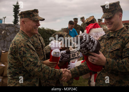 Generalleutnant Lawrence D. Nicholson, der kommandierende General des III Marine Expeditionary Force, Hände, die Weihnachten Strümpfe zu Marines im Camp Courtney, Okinawa, Japan, Dez. 22, 2017. Nicholson, Santa Claus, die Marines frohe Feiertage gewünscht und Geschenke von freiwilligen Organisationen an die III MEF Befehl element Weihnachtsatmosphäre zu verbreiten. (U.S. Marine Corps Foto von Cpl. Nelson Duenas / freigegeben) III MEF allgemein verbreitet sich Weihnachtsatmosphäre zu seinen Marines in Okinawa, Japan von # FIRMA PACOM Stockfoto